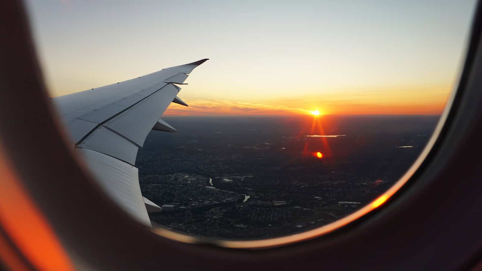 vue du ciel par le hublot d'un avion à l'heure dorée